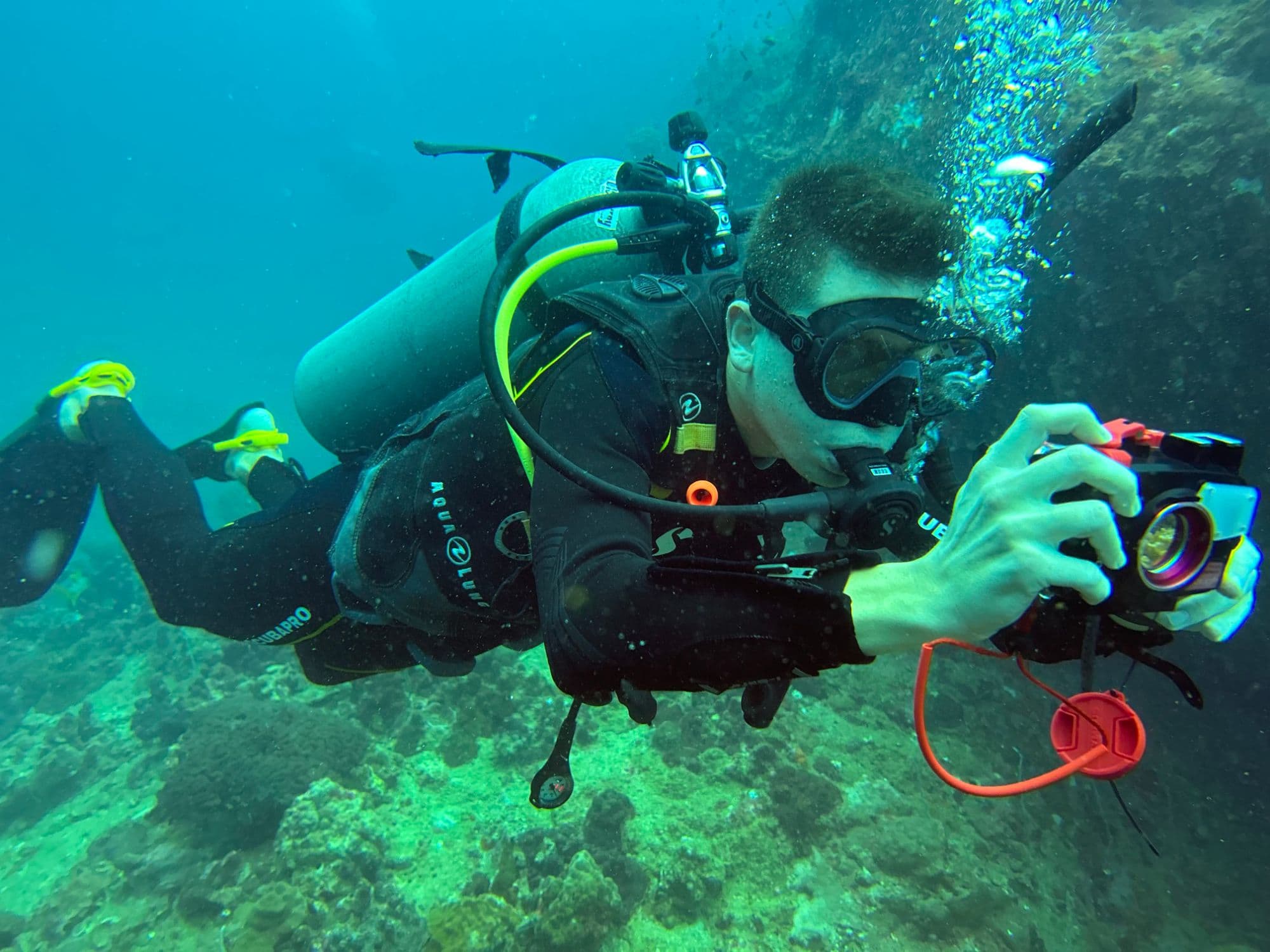 Plongeur avec un appareil photo sous-marin sur un récif du golfe de Thaïlande